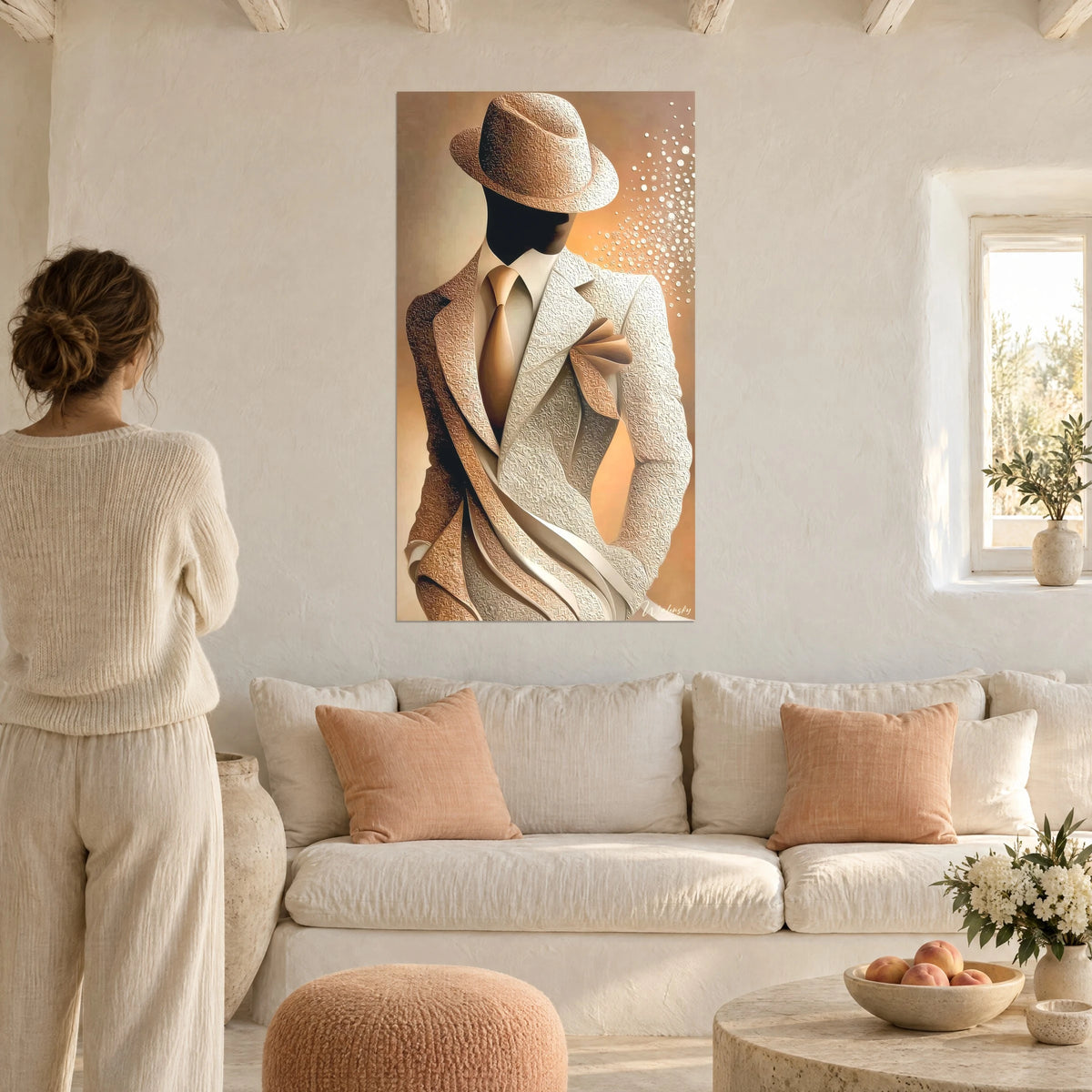 Cuadro dandy con sombrero de fieltro en relieve beige y cobre, una mujer de espaldas sobre un sofá en un salón luminoso