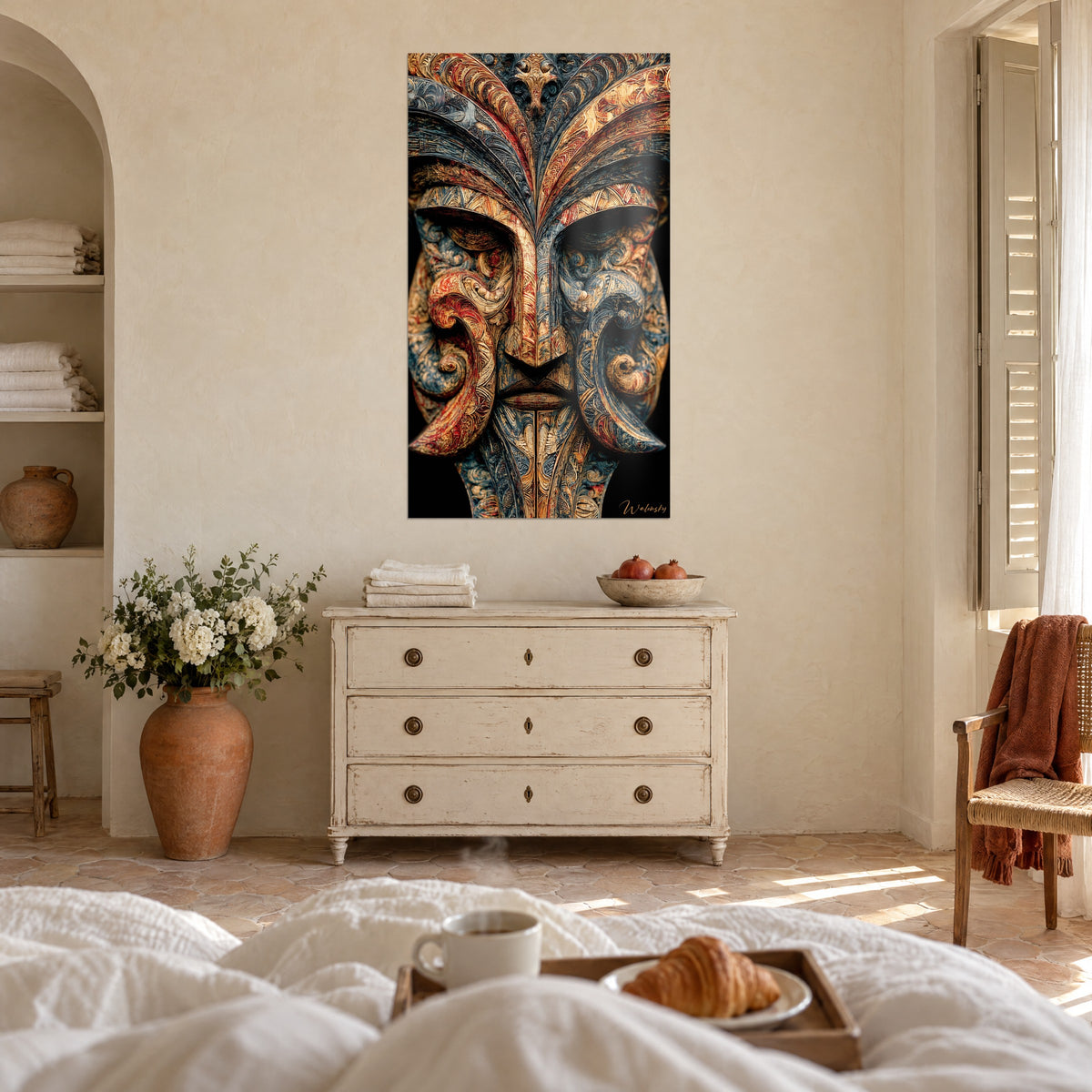 Tableau idole de bois ciselé aux arabesques rouge carmin et bleu nuit, nez en arête, au-dessus d'un lit dans une chambre claire