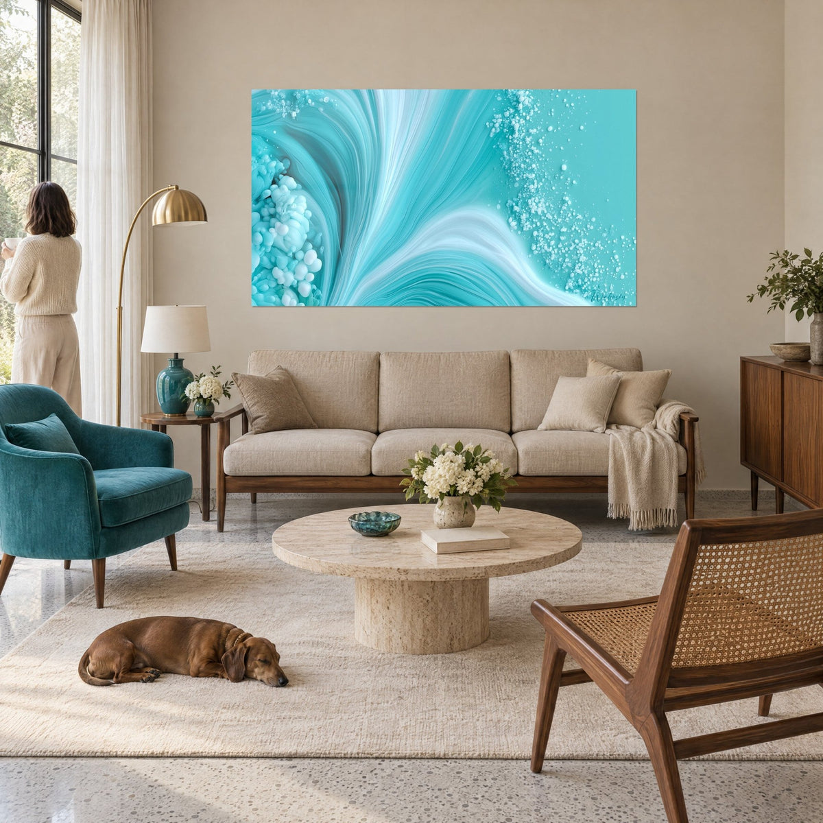 Tableau vague turquoise aux écumes blanches, bulles claires à droite, face à une femme de dos, au-dessus d'un canapé dans un salon lumineux