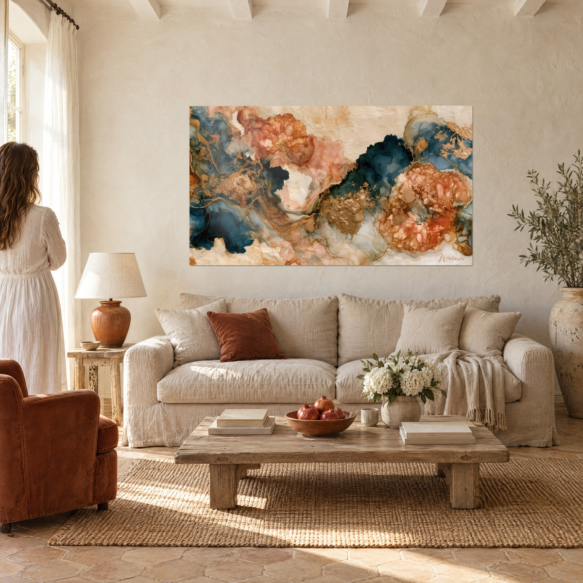 Tableau marbrures bleu marine et corail aux veines dorées, femme de dos, au-dessus d'un canapé dans un salon lumineux