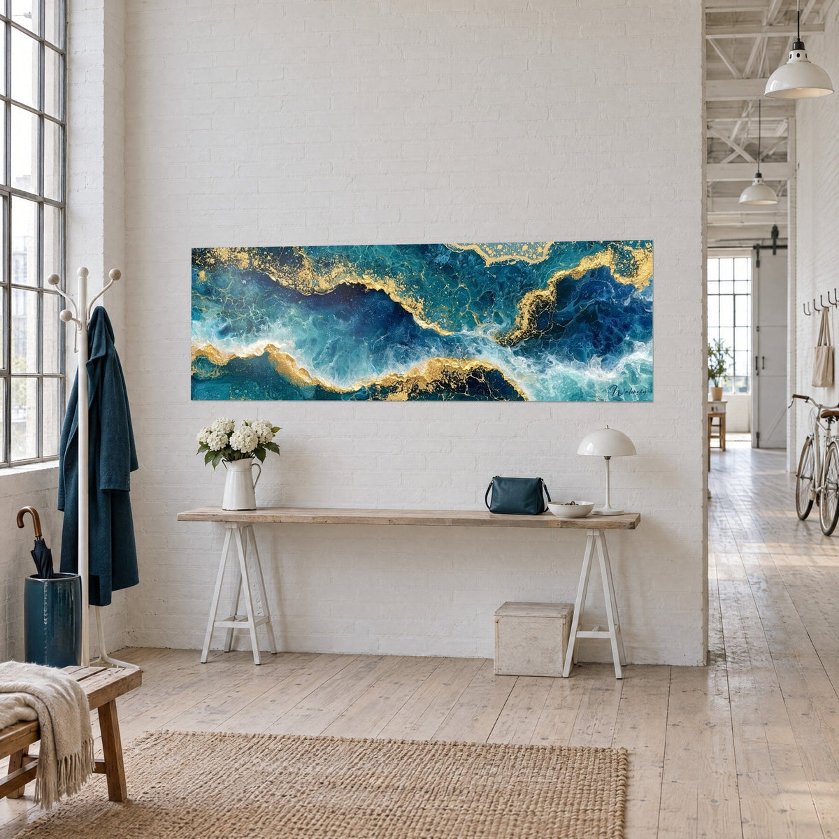 Tableau minerai doré fendant des vagues turquoise et indigo, panoramique posé sur un mur blanc de loft, vue de trois-quarts