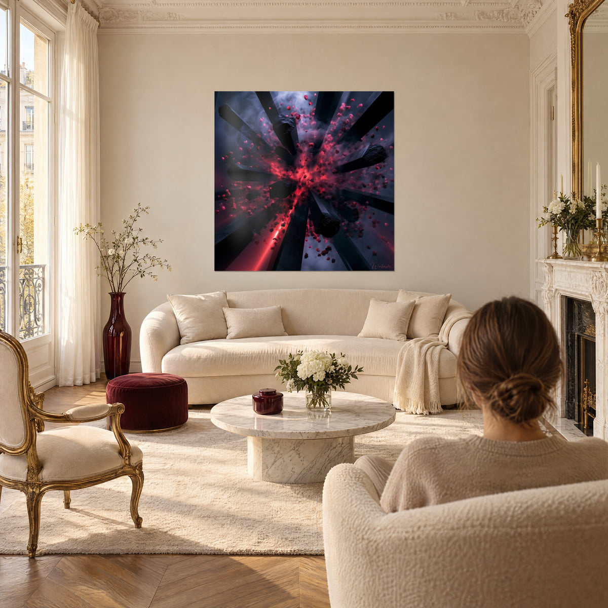 Wall art explosion in carmine and charcoal with suspended shards, woman seen from behind, above a sofa in a bright living room