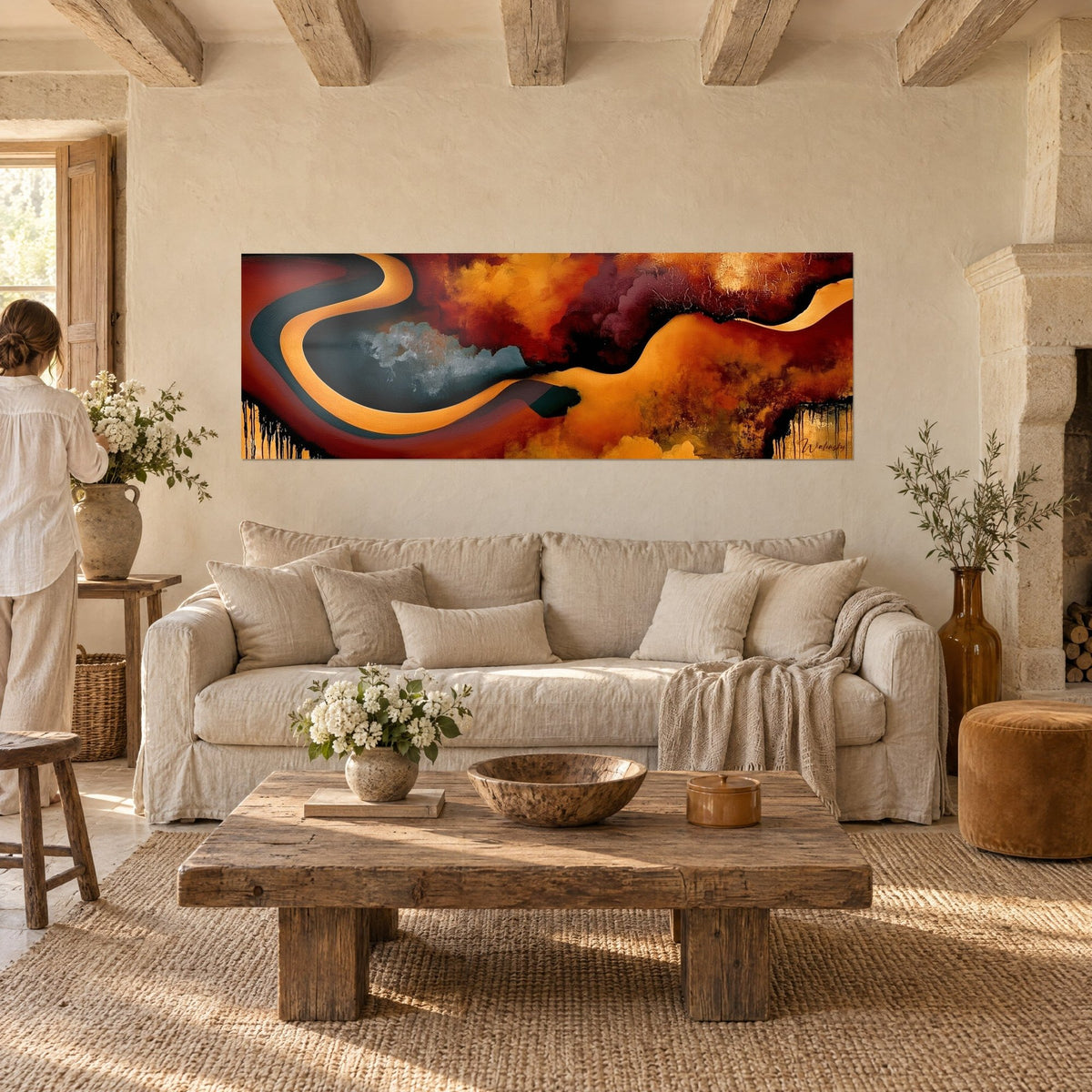 Tableau rivière sinueuse orange et anthracite, nuages bordeaux, deux personnes de dos, au-dessus d'un canapé dans un salon lumineux