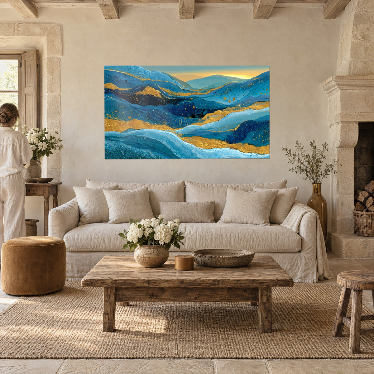 Quadro di un paesaggio di colline dolcemente ondulate in turchese e oro scintillante, cielo ambrato, sopra un divano in un soggiorno luminoso