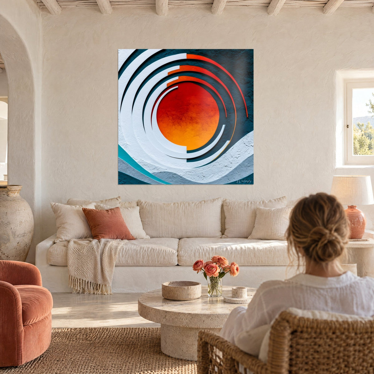 Cuadro sol naranja rodeado de arcos blancos en relieve sobre fondo azul petróleo, encima de un sofá en un salón luminoso