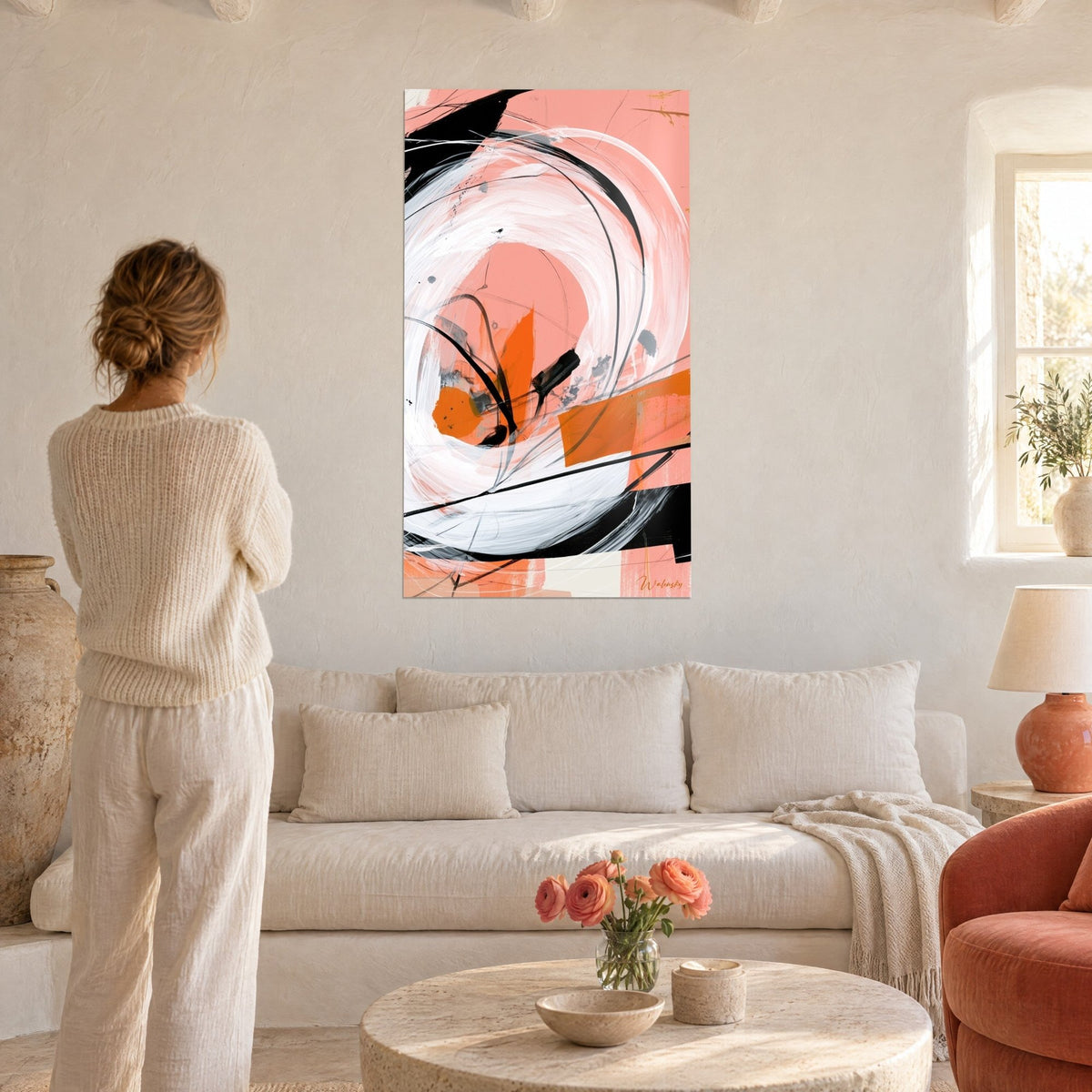 Tableau spirale blanche en coups de pinceau épais sur fond corail, traits noirs, femme de dos, au-dessus d'un canapé dans un salon lumineux