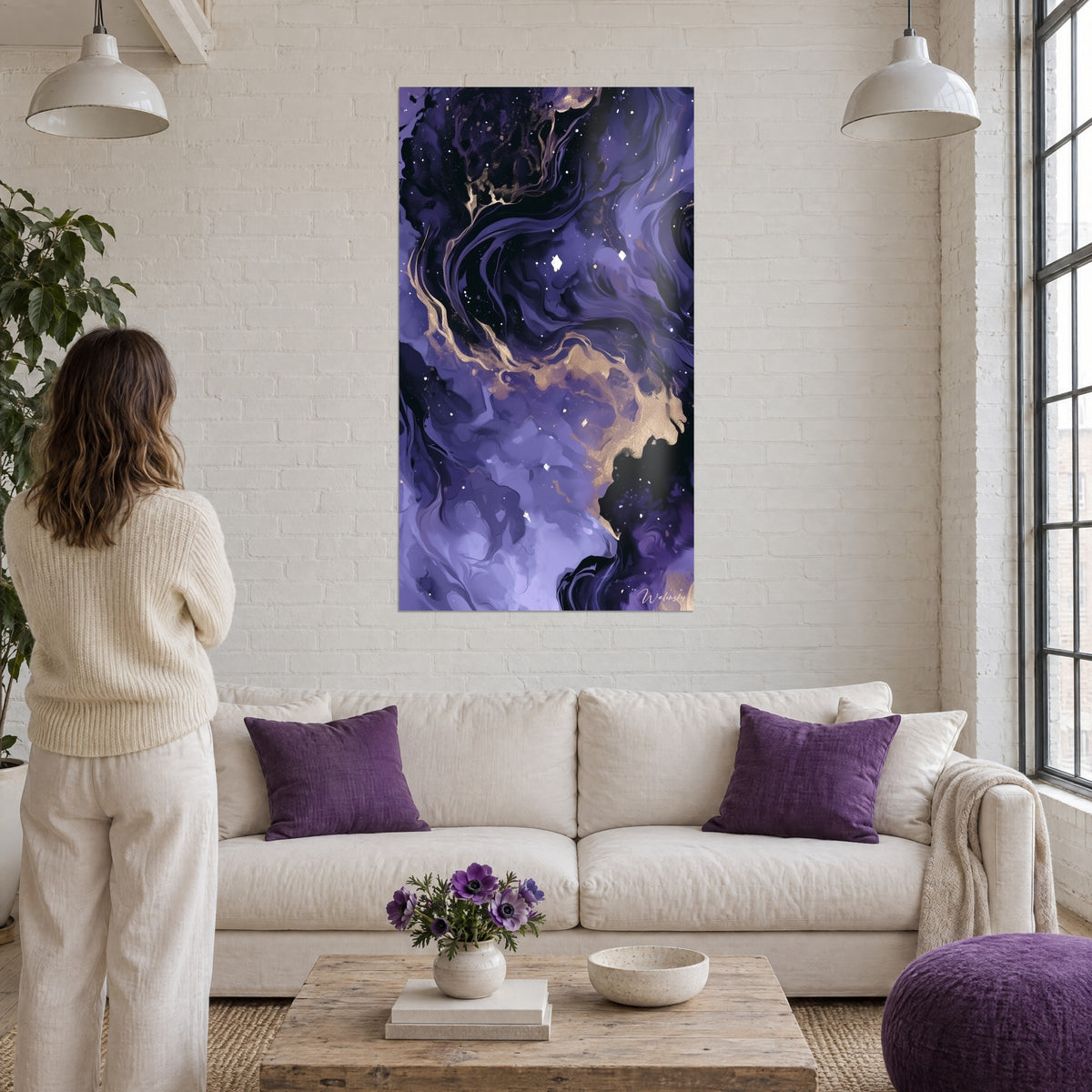 Gemälde Nebel in Violett mit goldenen Adern, verstreute weiße Sterne, Frau von hinten über einem Sofa in einem hellen Wohnzimmer