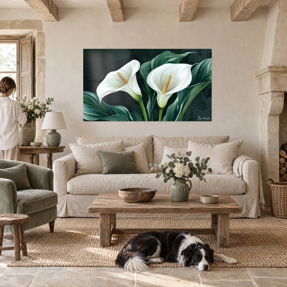 Wall art white arum lilies with ivory spathes on a deep green background, a person seen from behind and a collie, above a sofa in a bright living room