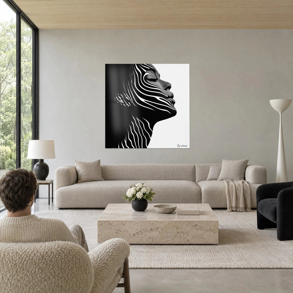 Gemälde weibliches Profil mit weißen Streifen auf schwarzem Hintergrund, zwei Personen von hinten, über einem Sofa in einem hellen Wohnzimmer