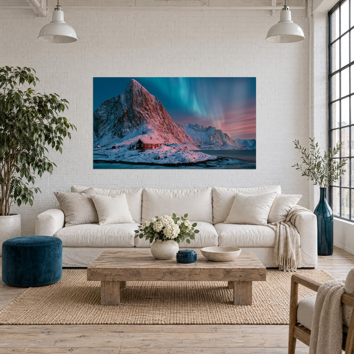 Tableau cabane rouge sous un pic rosé et ciel vert d'aurore, neige blanche, au-dessus d'un canapé dans un salon lumineux