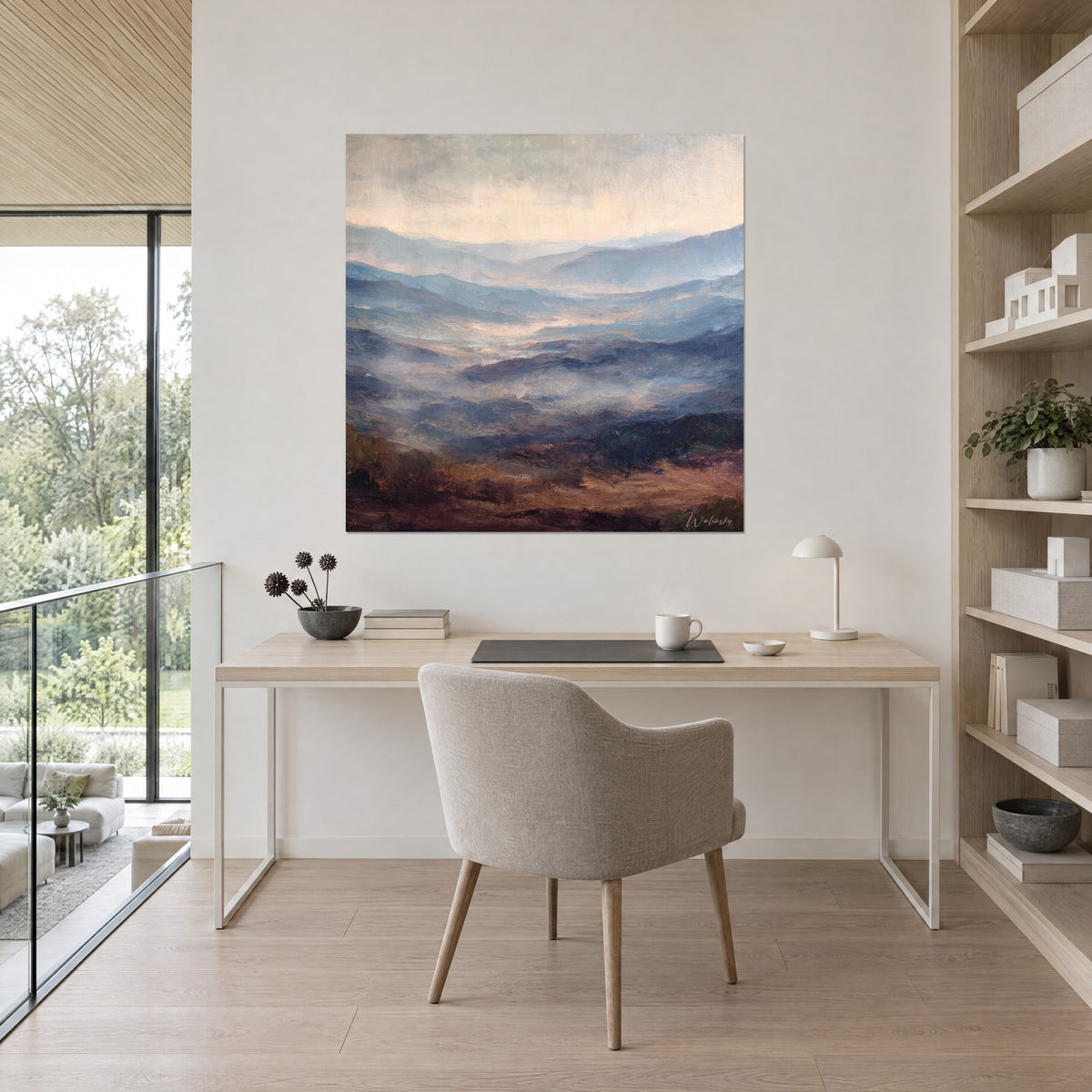 Wall art horizon of bluish ridges under a pale peach sky, brown earth in the foreground, in a bright office