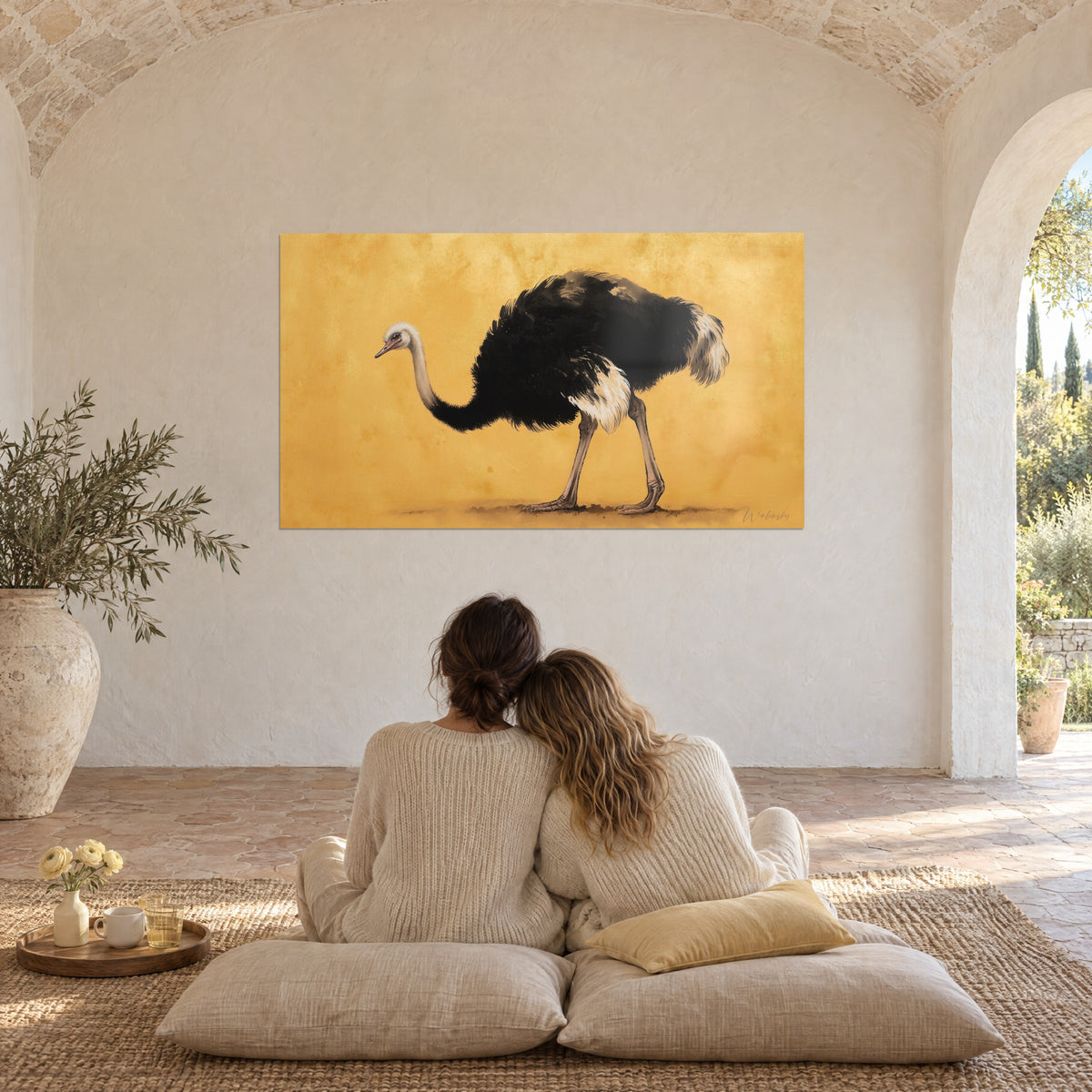Tableau autruche mâle noire, ailes ivoire et bec rosé, fond ocre mordoré, couple enlacé de dos sur des coussins au sol