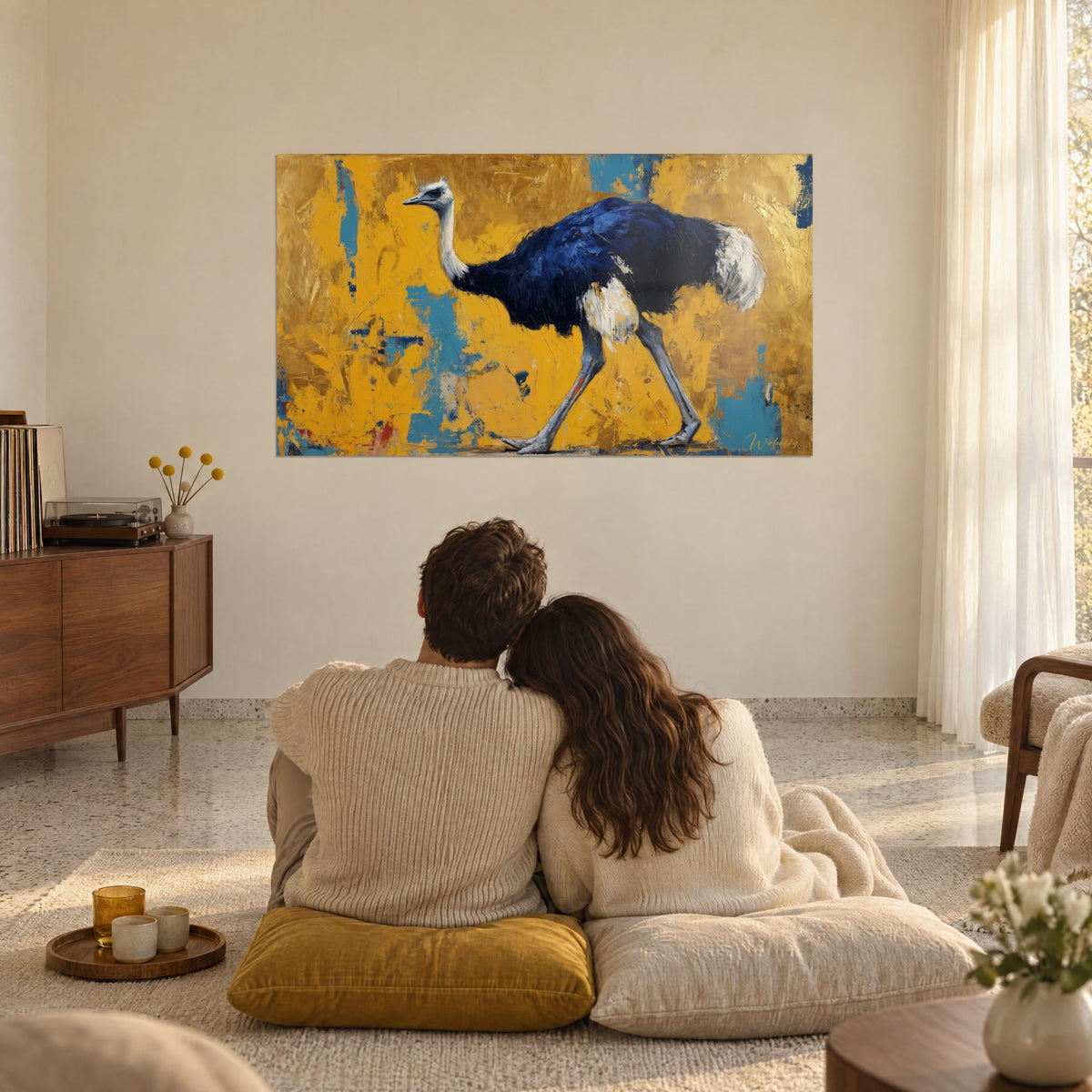 Tableau autruche traversant un fond doré éclaboussé de bleu turquoise, plumage indigo, couple enlacé de dos sur des coussins moutarde