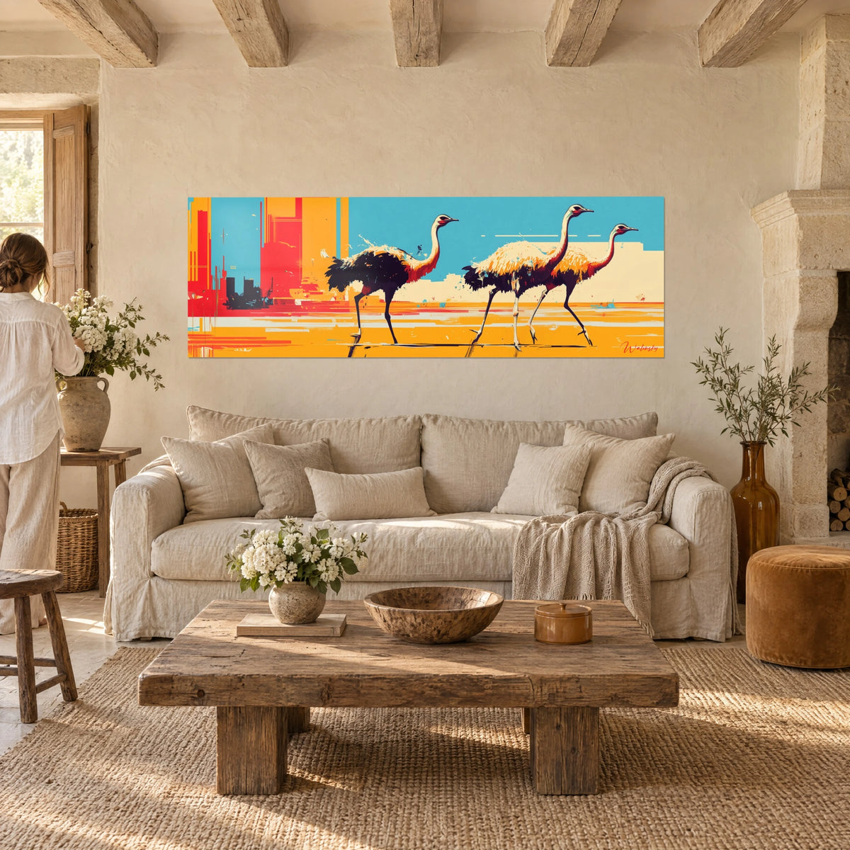 Wall art three ostriches in full stride, black and cream plumage, sky blue and yellow background, above a sofa in a bright living room