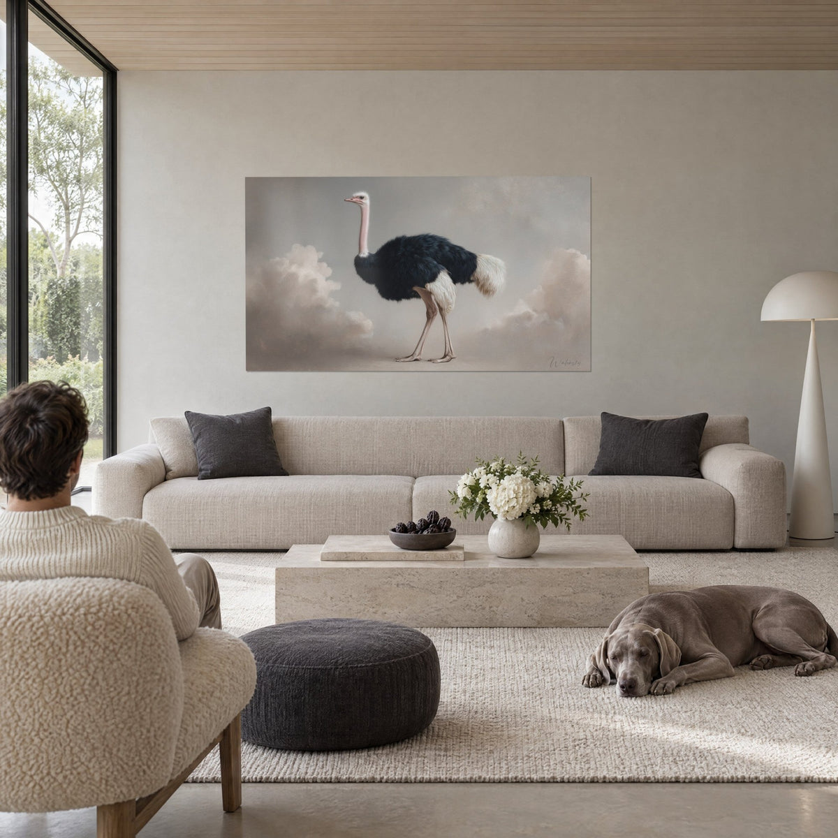Gemälde eines Straußes mit schwarz-weißem Gefieder vor beigen Wolken, über einem Sofa in einem hellen Wohnzimmer