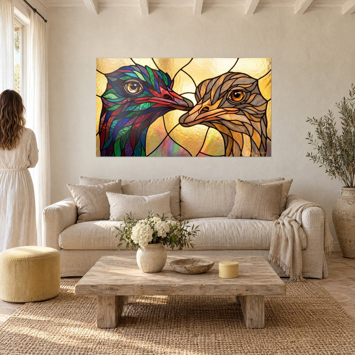 Tableau duo d'autruches en vitrail, plumage vert émeraude et rouge face à un cou beige, au-dessus d'un canapé dans un salon lumineux