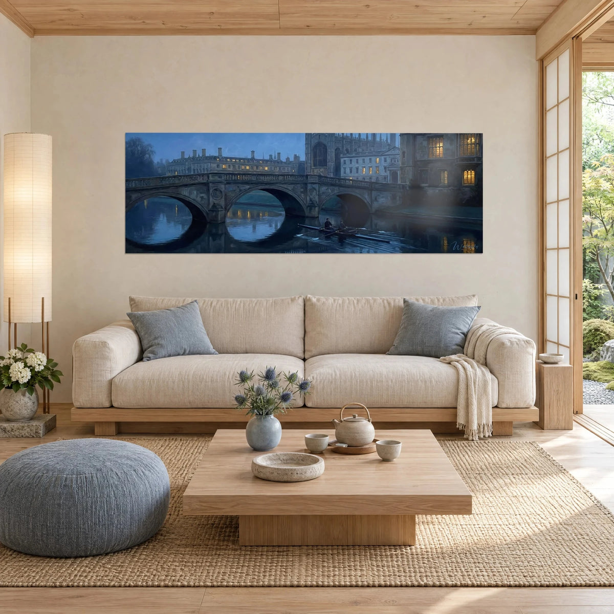 Quadro ponte di pietra a tre arcate sul fiume, blu notte e finestre ambrate, sopra un divano in un soggiorno luminoso