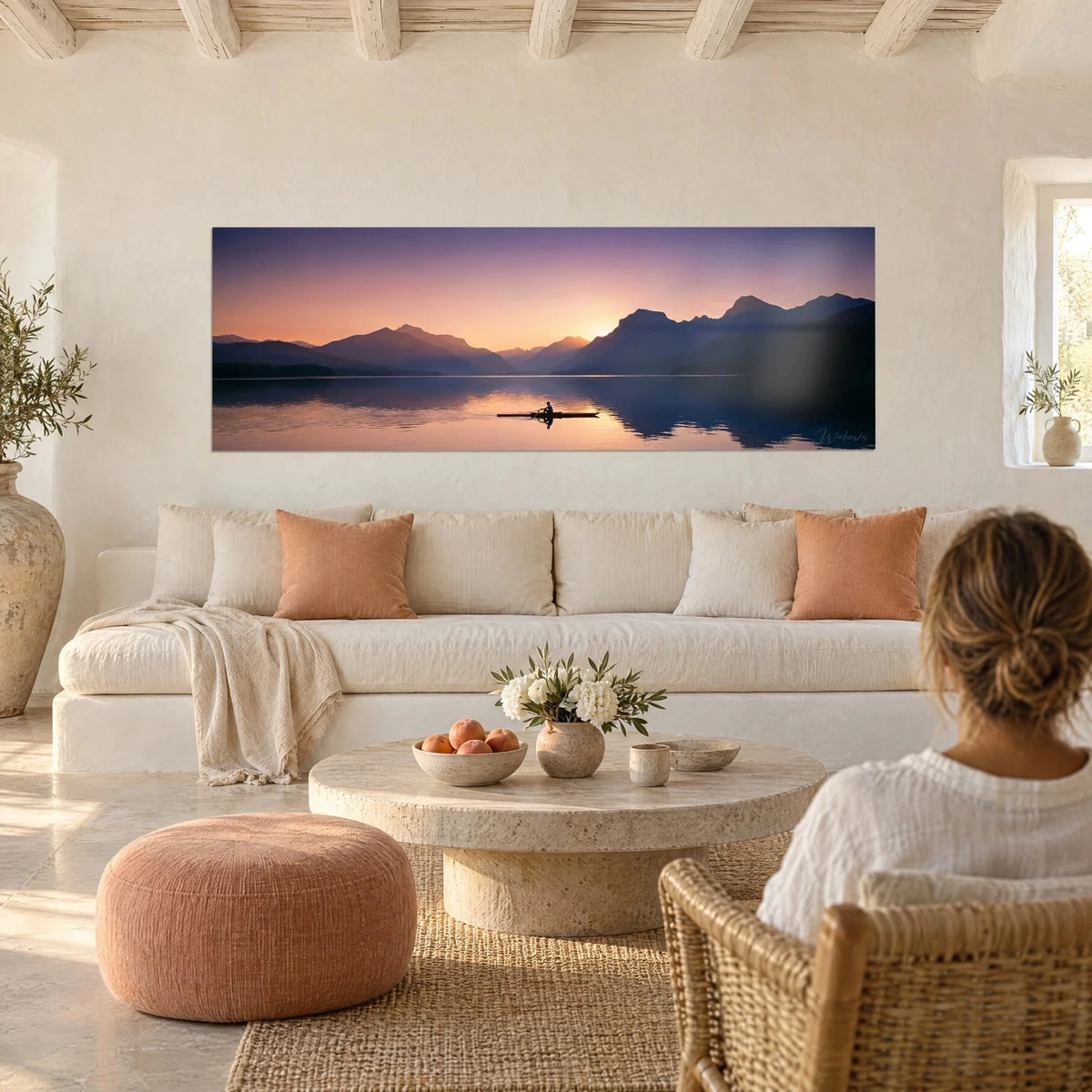 Tableau rameur solitaire glissant sur un lac pourpre et orangé, montagnes bleutées, au-dessus d'un canapé dans un salon lumineux