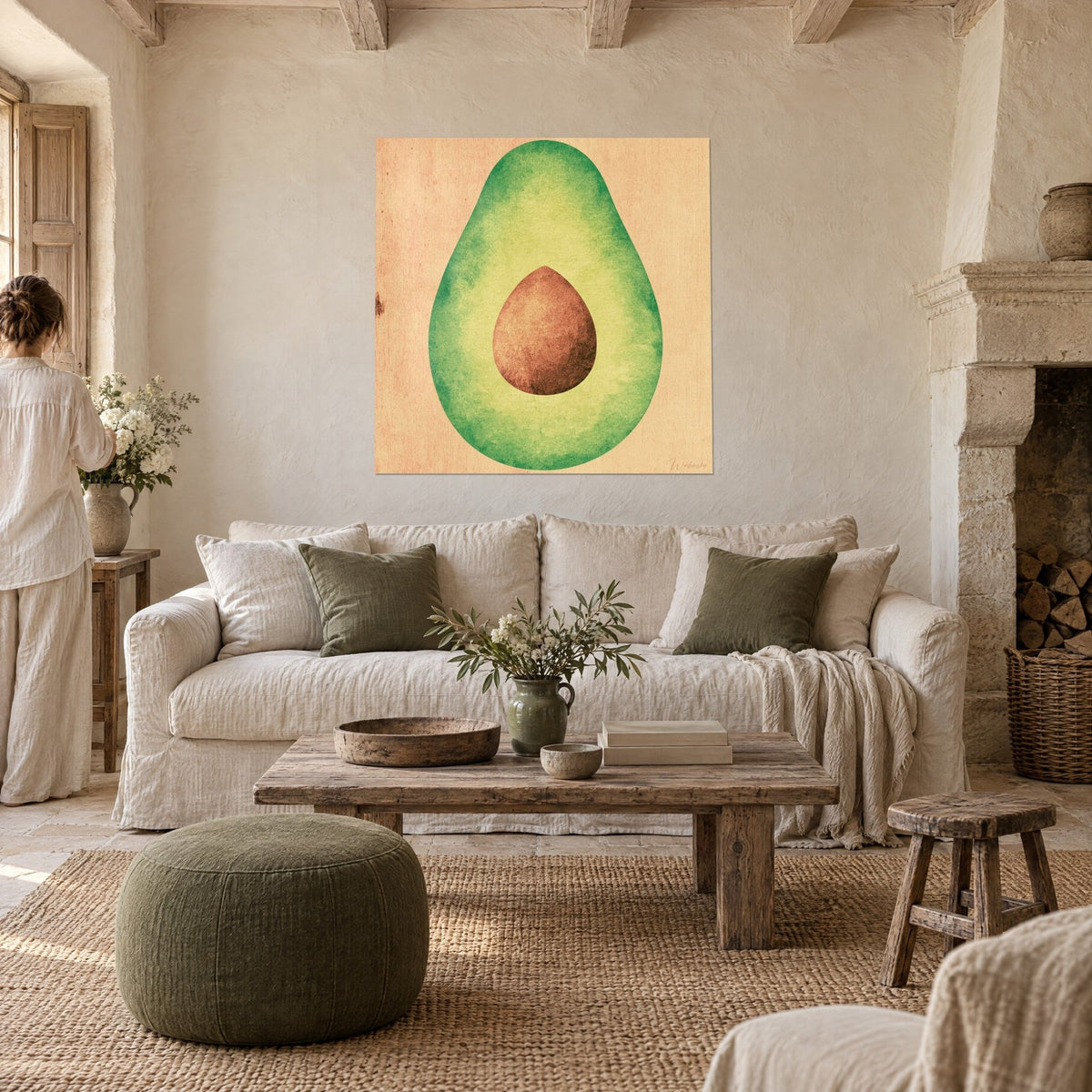 Tableau demi-avocat vert tendre au noyau brun, fond pêche, accroché au-dessus d'un canapé dans un salon lumineux