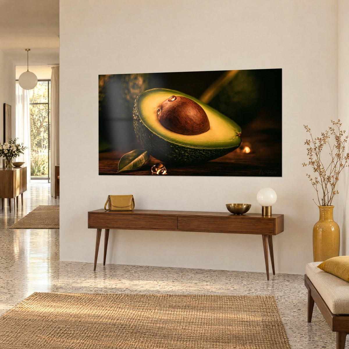 Tableau fruit coupé en deux, peau grenue vert profond, noyau acajou et reflets de fenêtres, sur un mur beige dans l'entrée