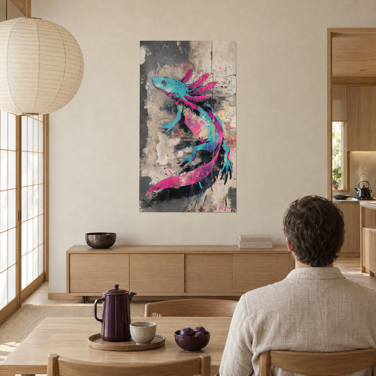 Πίνακας αξολότλ pop-art σε κυανό και μαγέντα με χρυσές στάζες, μπεζ σοβάς τοίχος, δίπλα σε άντρα από την πλάτη καθισμένο σε τραπέζι, καυτός καφές