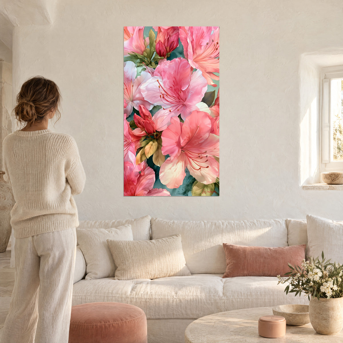 Cuadro de azaleas rosa caramelo y blanco nacarado con estambres naranjas, mujer de espaldas, sobre un sofá en un salón luminoso