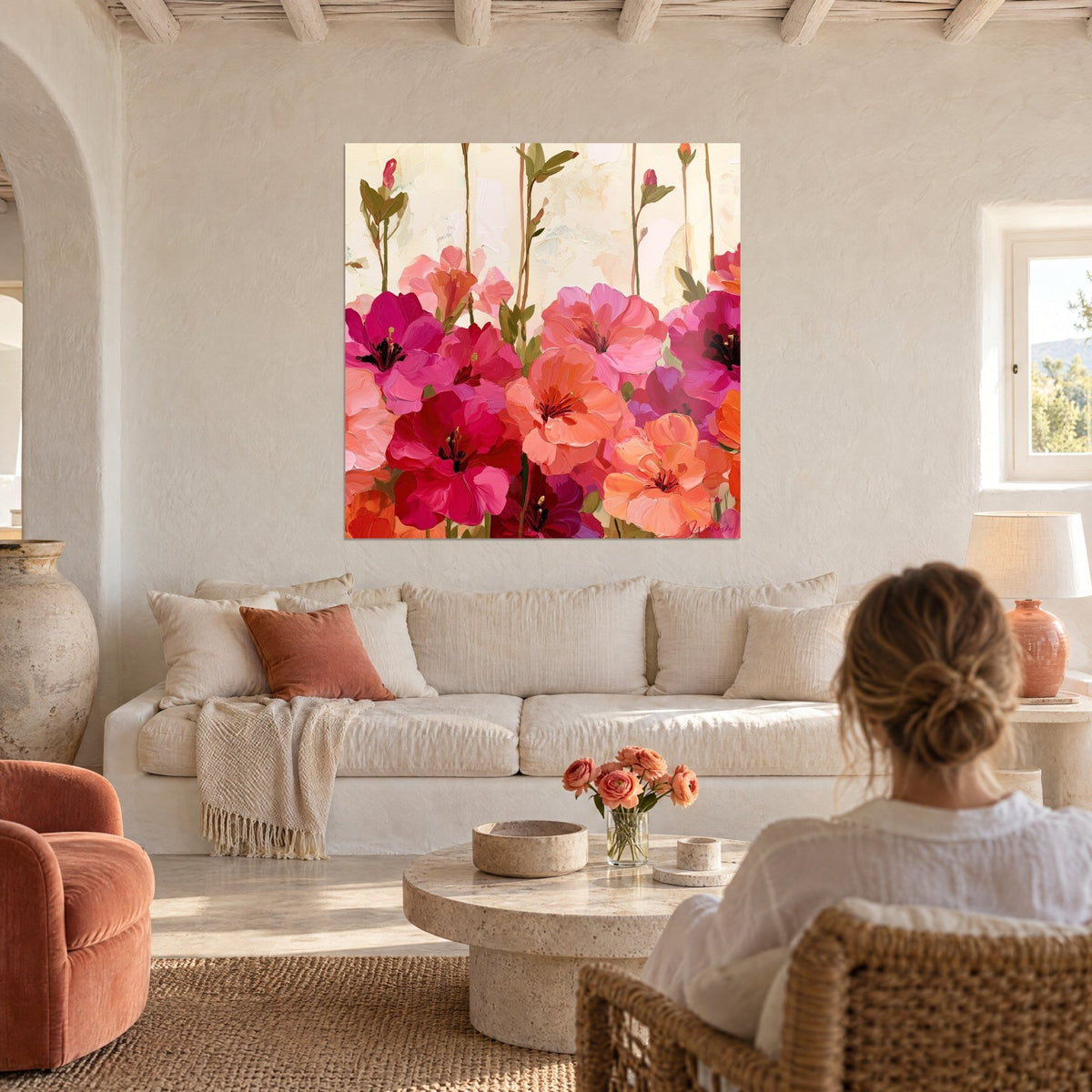 Tableau fleurs d'azalée roses et corail aux étamines noires, au-dessus d'un canapé dans un salon lumineux