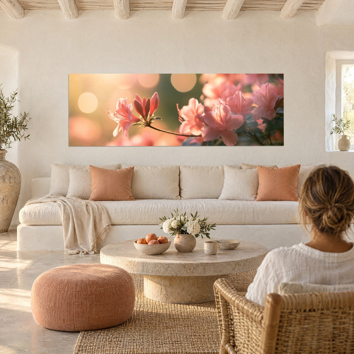 Tableau azalées roses en fleur, pétales saumon et lueurs dorées floues, avec deux personnes de dos au-dessus d'un canapé dans un salon lumineux