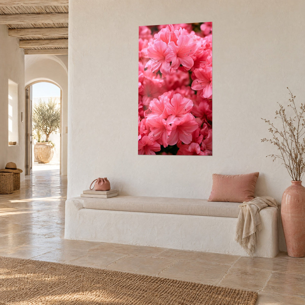 Quadro massa fitta di fiori rosa dai petali arricciati, toni fucsia e corallo, su parete intonacata bianca, panca in pietra