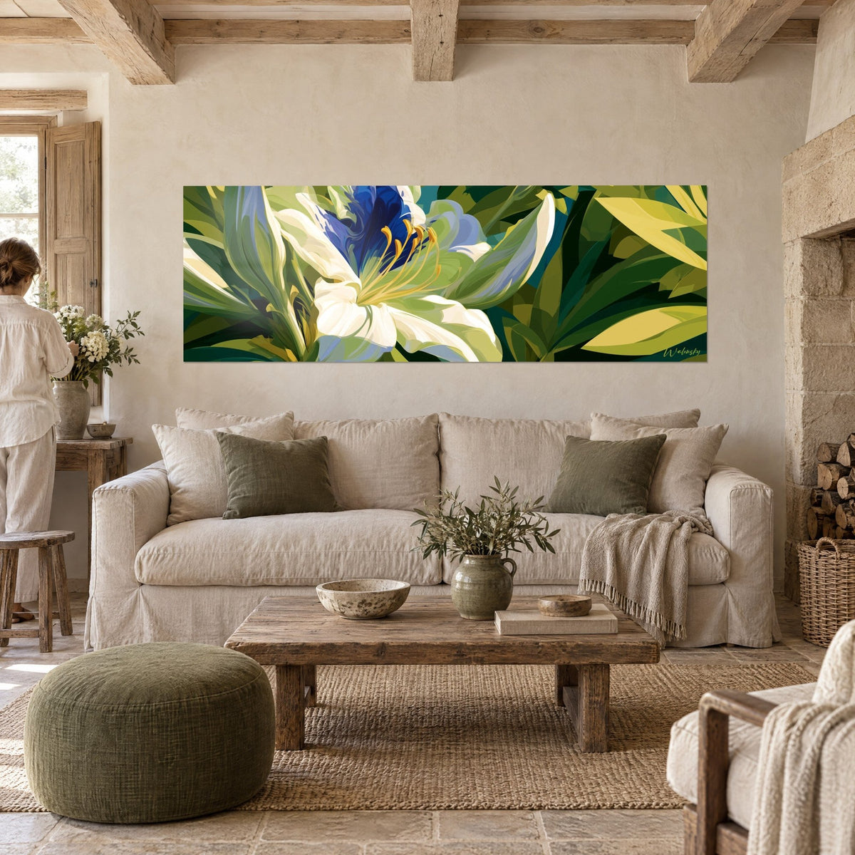Tableau lis blanc aux pétales crème et cœur bleu roi, étamines dorées, feuillage olive, au-dessus d'un canapé dans un salon lumineux