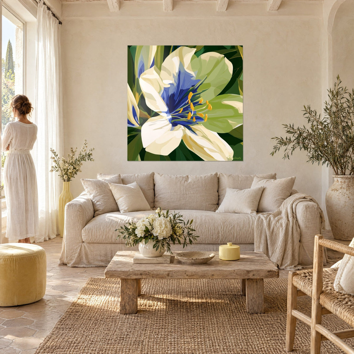 Tableau fleur blanche aux étamines safran et cœur indigo, feuillage vert sombre, femme de dos au-dessus d'un canapé dans un salon lumineux