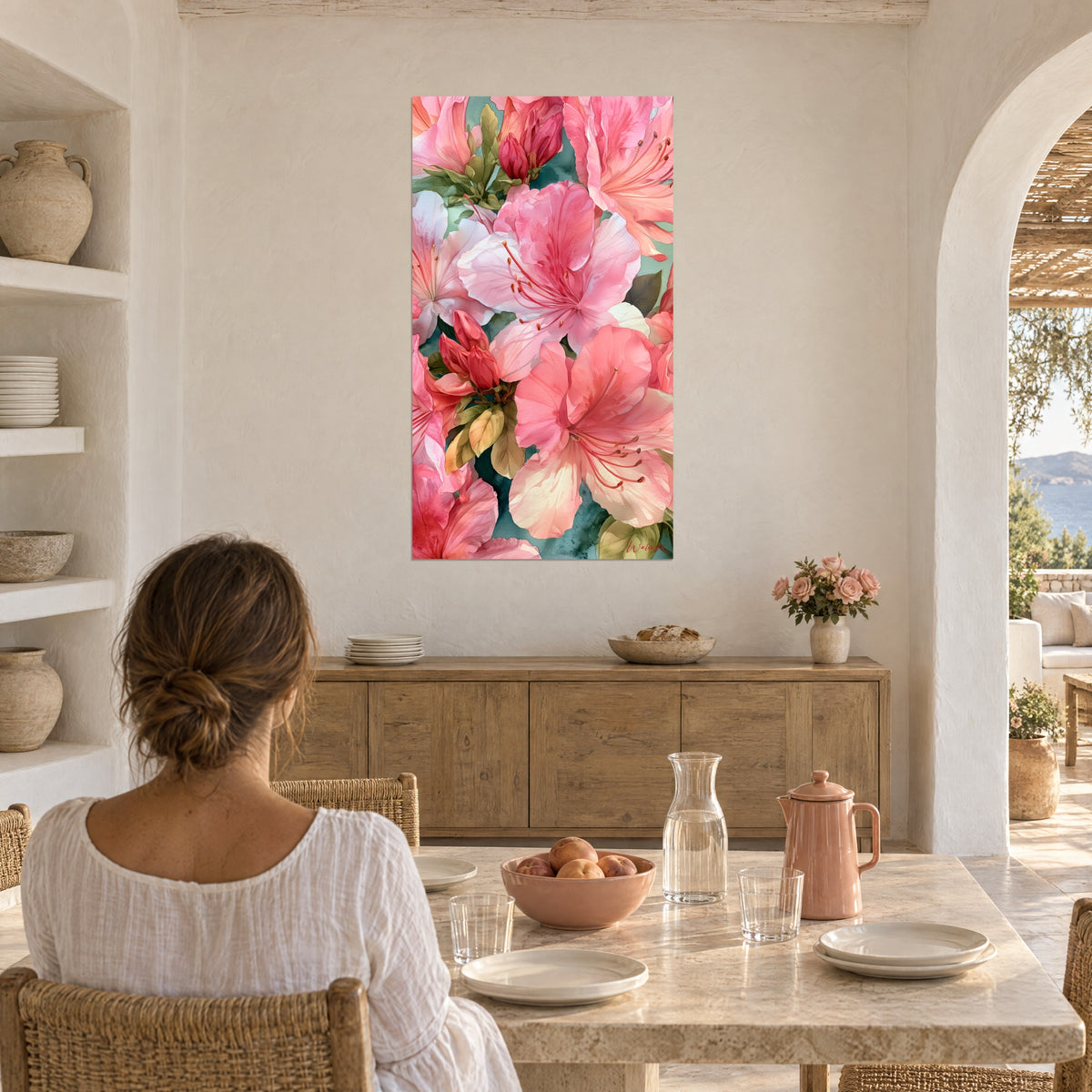 Cuadro de floración de azaleas en acuarela rosa pálido y verde salvia, mujer de espaldas sentada a una mesa cerca de un arco blanco
