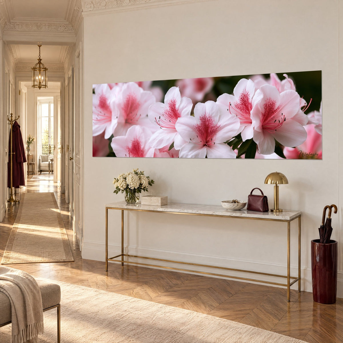 Cuadro panorámico de flores de azalea, pétalos marfil y rosa, estambres finos, colgado sobre una consola dorada en la entrada