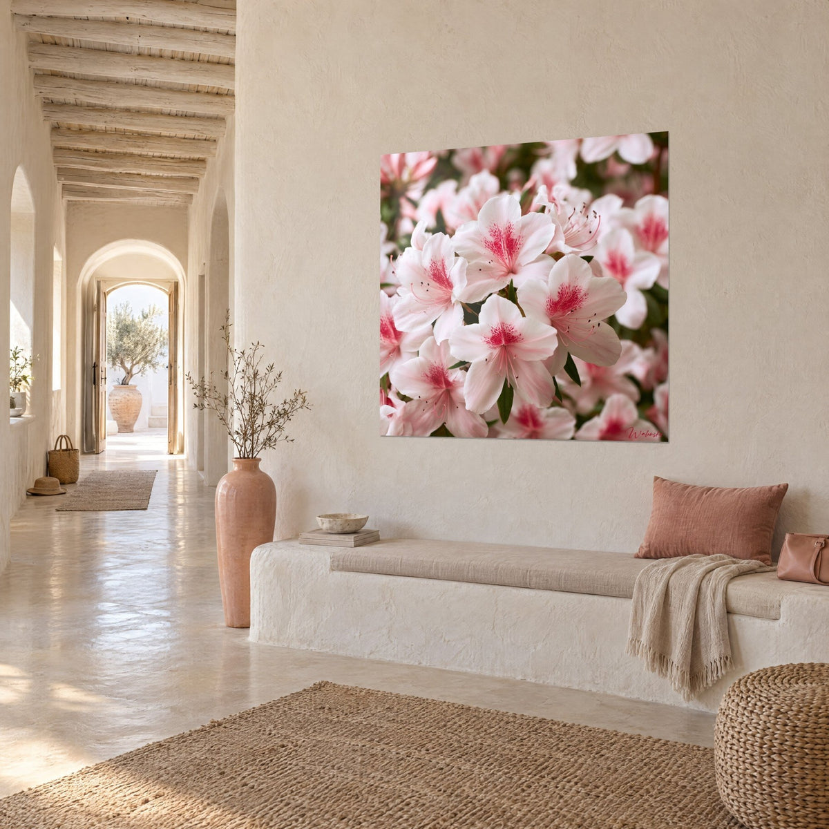 Wall art pearly corollas speckled with fuchsia, dark green foliage, white bench and rattan pouf in a vaulted hallway