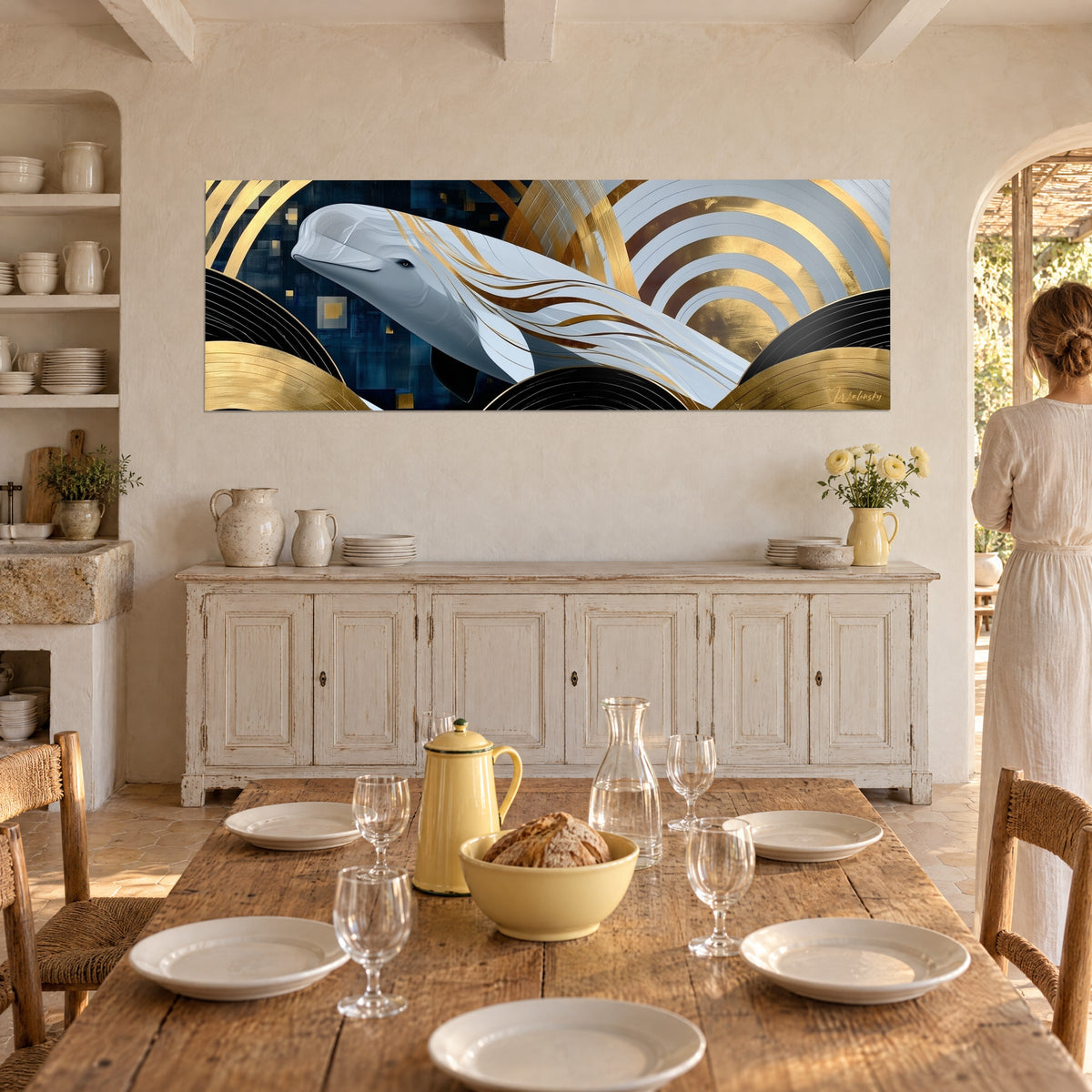 Tableau géant des mers blanc cassé, cercles dorés et noirs, fond bleu nuit, au-dessus d'un buffet blanc, femme de dos
