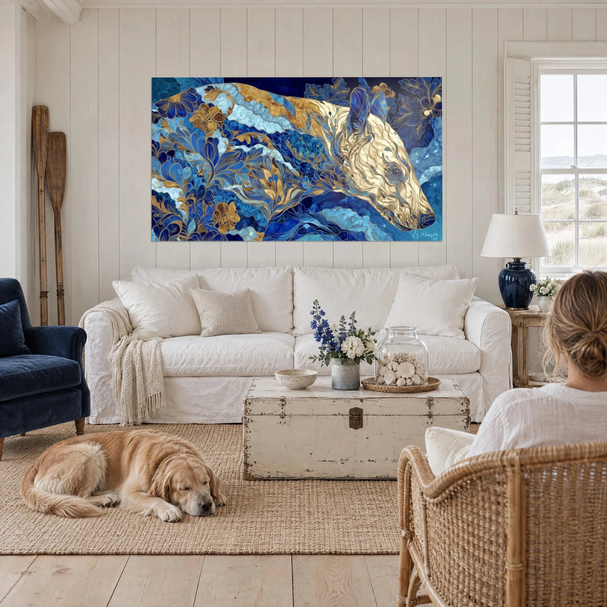 Tableau bête préhistorique ornementale bleu cobalt et or, museau crème, au-dessus d'un canapé dans un salon lumineux