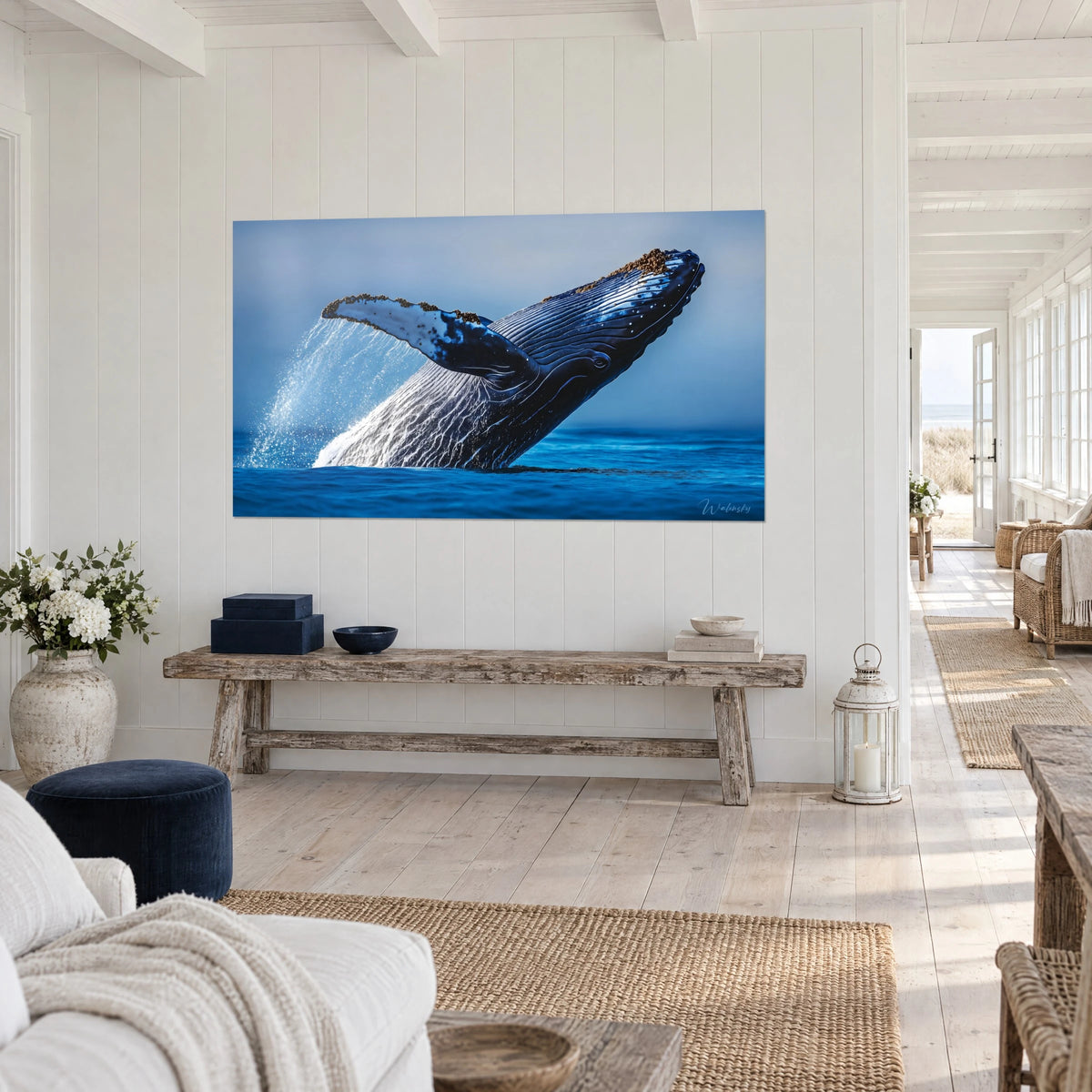 Cuadro cetáceo gigante brincando fuera del océano ultramar, aleta pectoral moteada de blanco, en la pared de una casa junto al mar