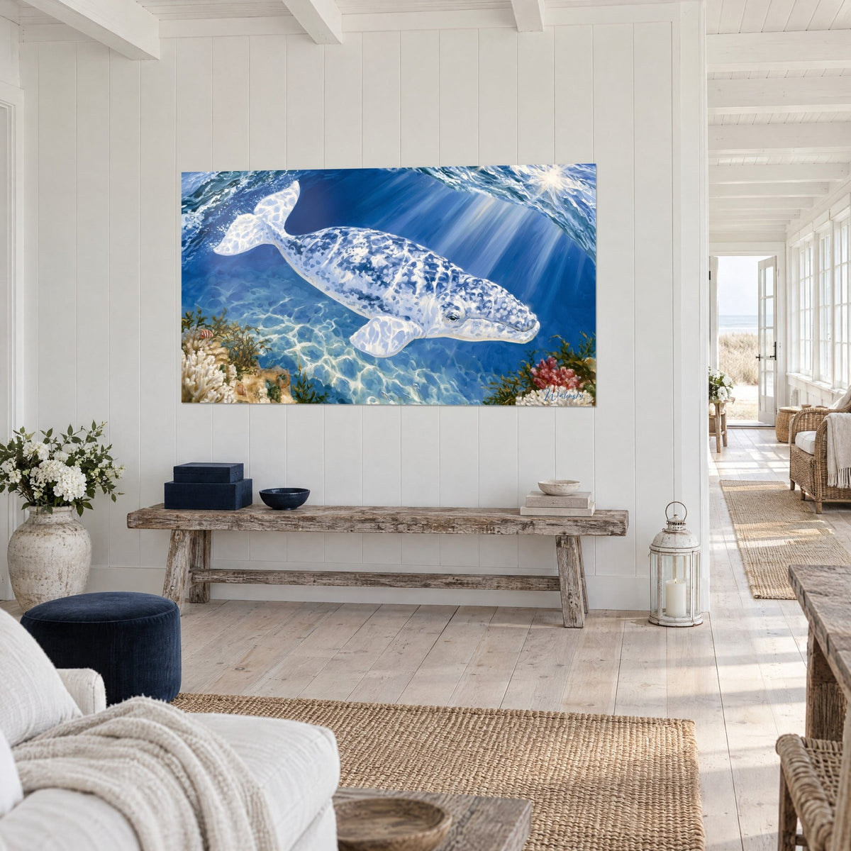Tableau cétacé ivoire aux motifs indigo glissant dans une eau turquoise, algues vertes au fond, mur blanc et banc en bois brut