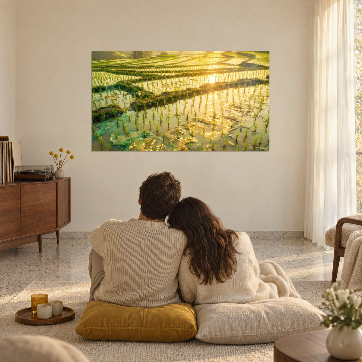 Quadro mosaico di risaie baciate dall'oro, verde giada e miele, coppia abbracciata di spalle, cuscini senape sul pavimento di un soggiorno