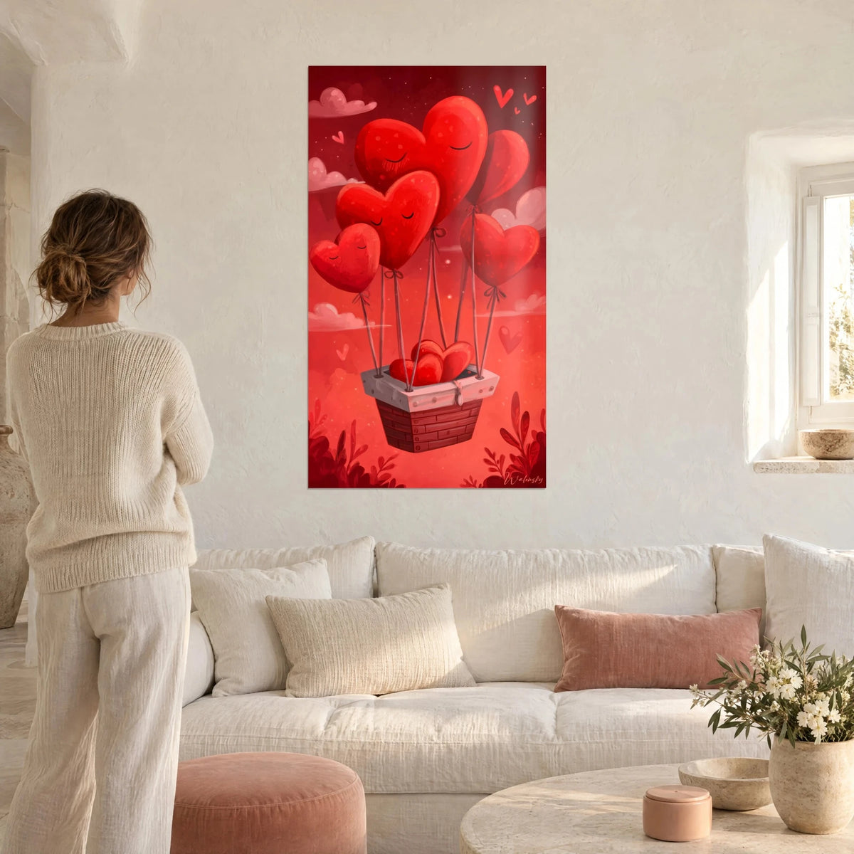 Wall art heart balloons, red hearts asleep tied to a brick basket, crimson background and pink clouds, above a sofa in a bright living room