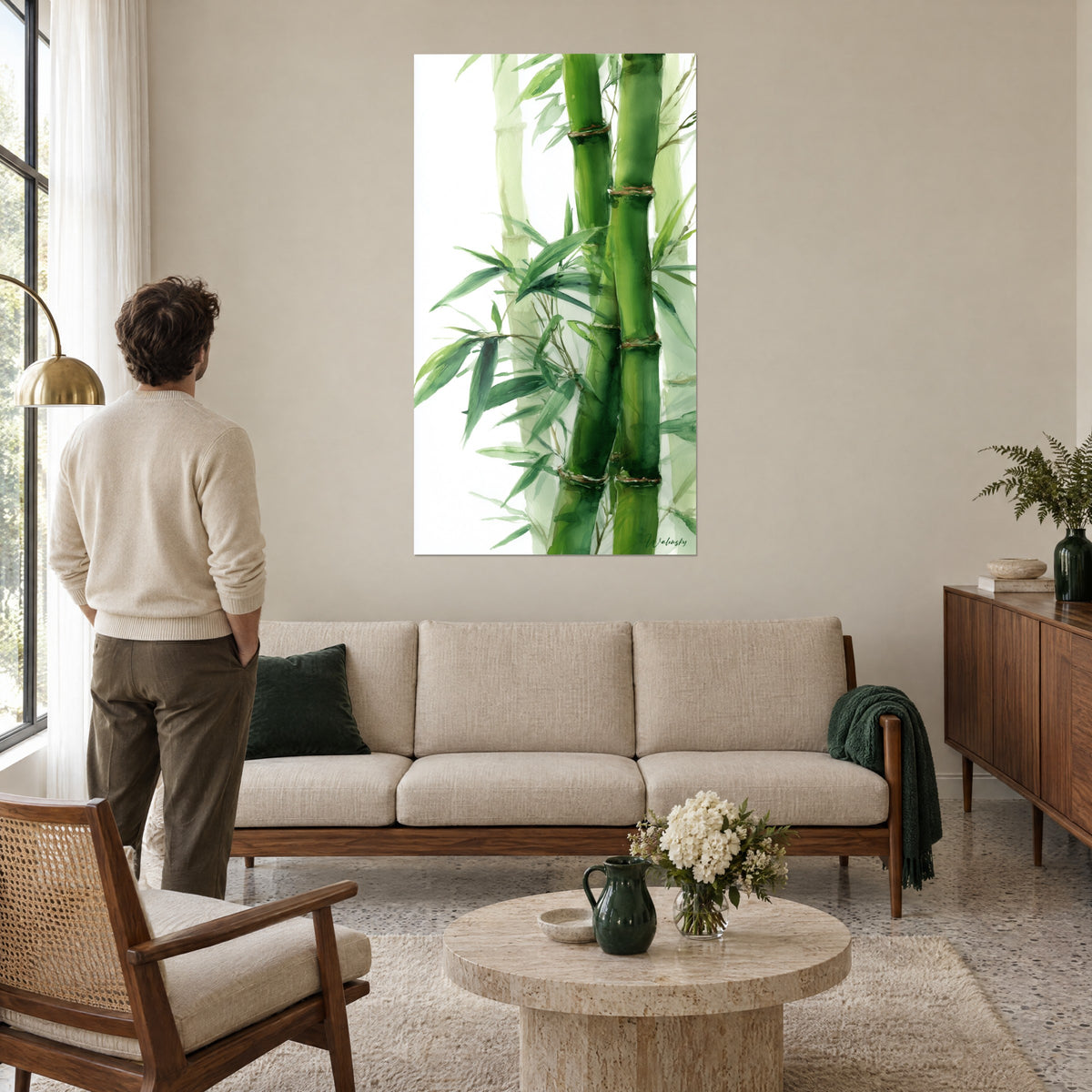Tableau bambous en aquarelle aux tiges vert tendre et feuilles émeraude sur fond blanc, au-dessus d'un canapé dans un salon lumineux