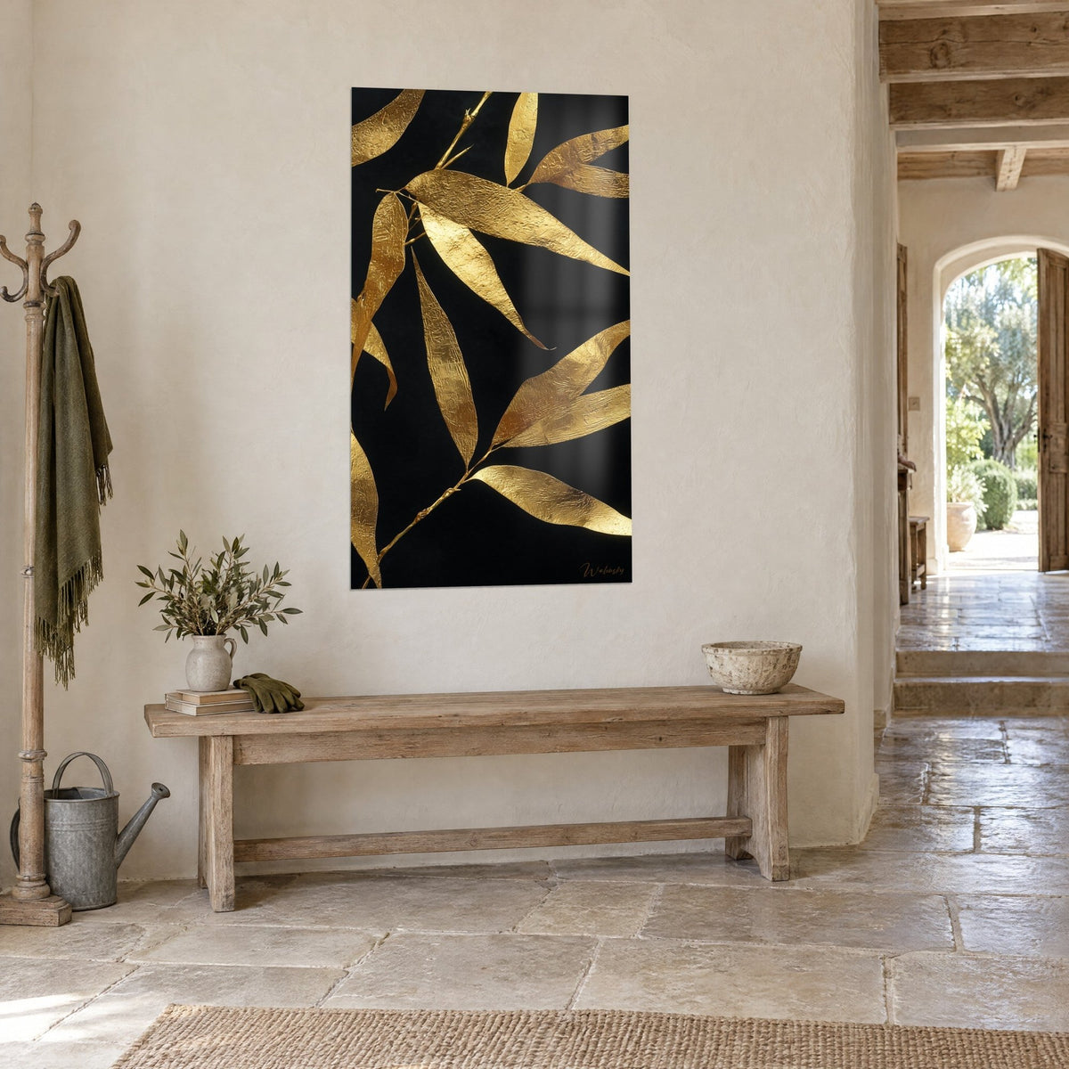 Tableau branche aux feuilles d'or ciselées sur fond d'encre noire, vue de trois-quarts, console en bois et sol de pierre claire