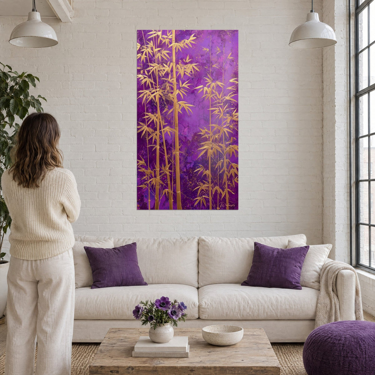 Tableau bambou doré sur fond violet marbré, tiges ocre et feuilles lancéolées, au-dessus d'un canapé dans un salon lumineux
