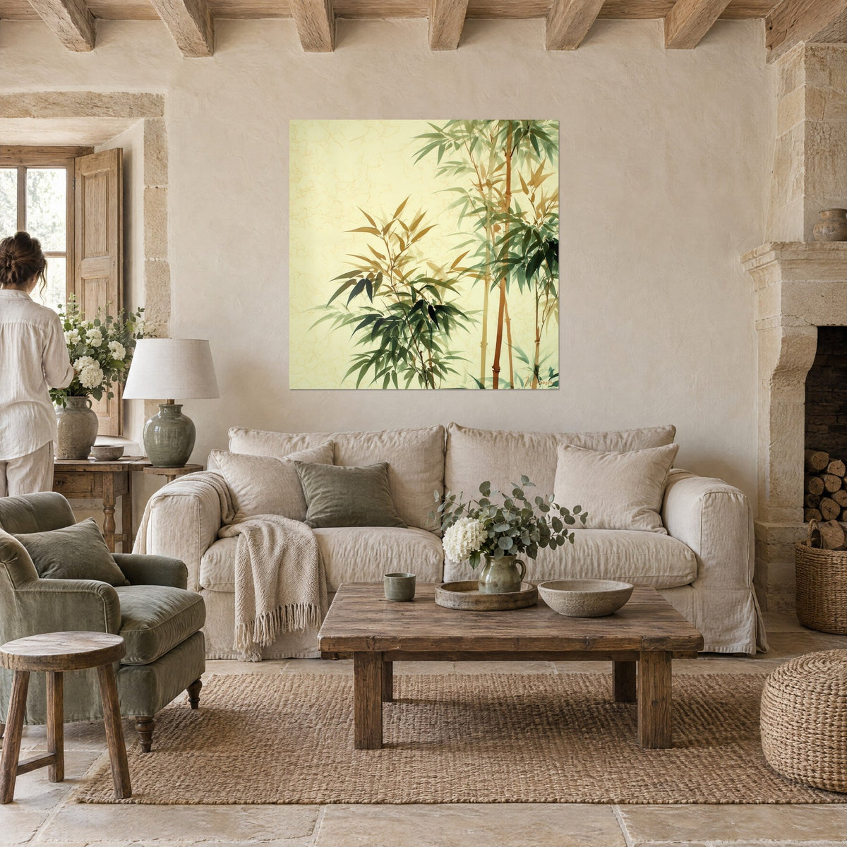 Tableau bambous en lavis vert sauge et ocre sur fond crème craquelé, deux personnes de dos, au-dessus d'un canapé dans un salon lumineux