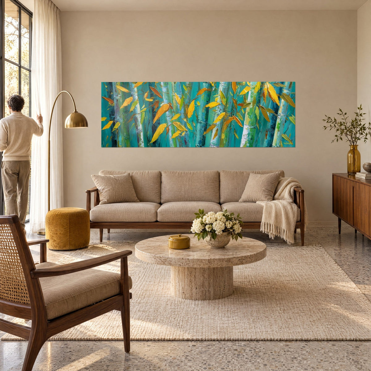 Tableau forêt de bambous turquoise aux feuilles jaune doré, un homme de dos, au-dessus d'un canapé dans un salon lumineux