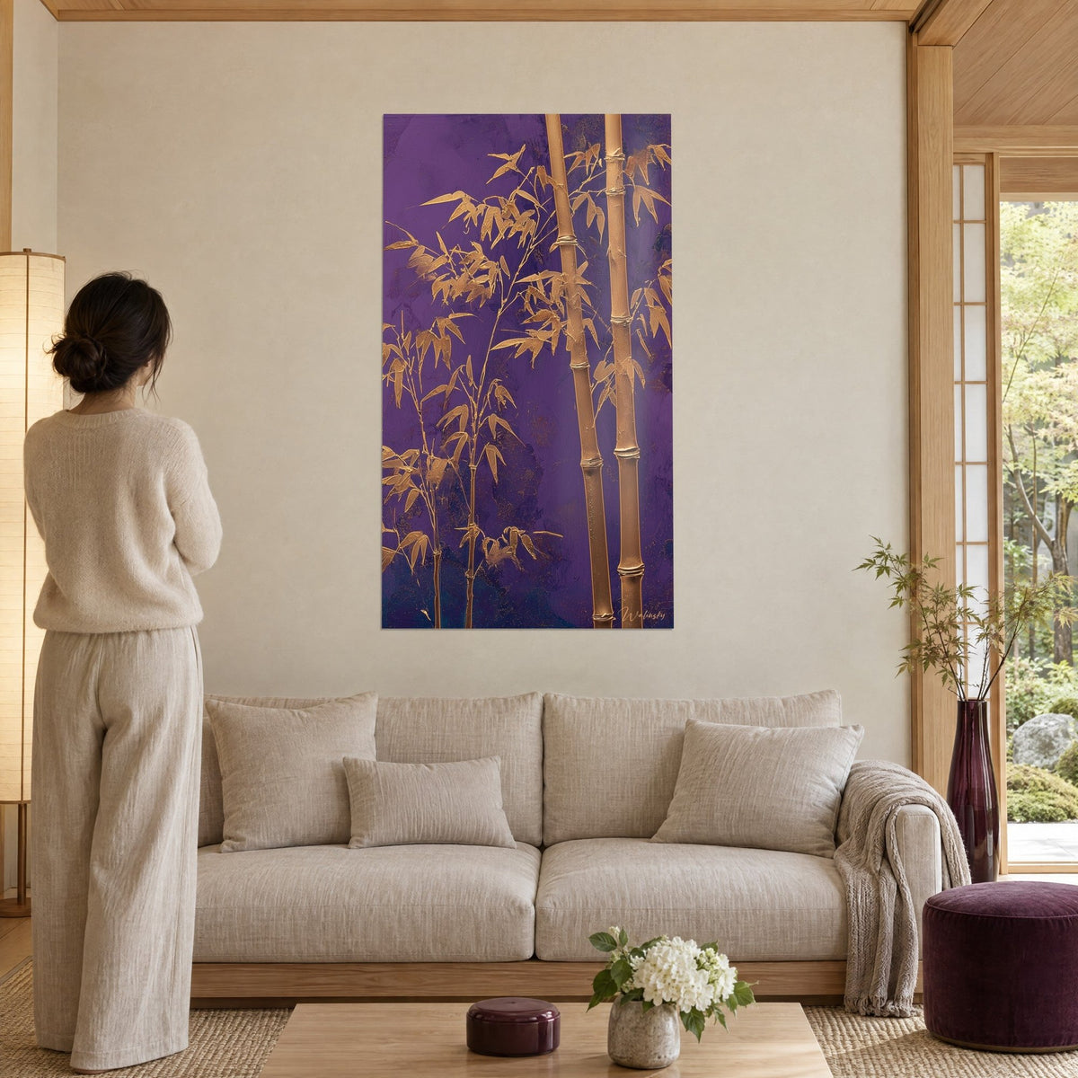 Tableau bambous dorés en relief sur fond violet profond, personne de dos, au-dessus d'un canapé dans un salon lumineux