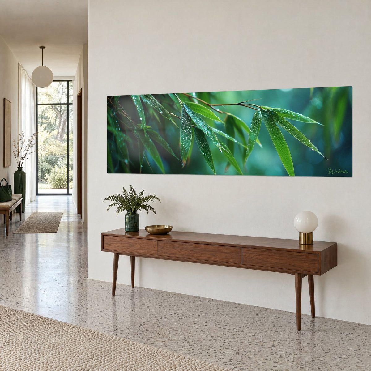 Wall art of a hanging bamboo branch, green blades and crystal droplets on a turquoise background, above a wooden console in a hallway