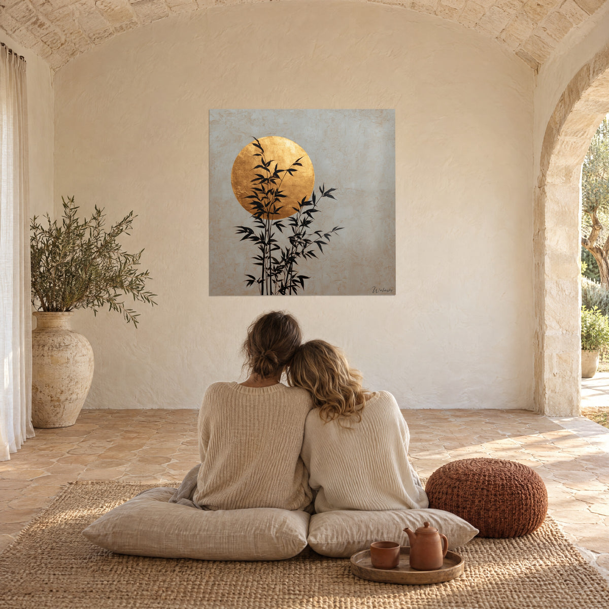 Quadro bambù grafici neri su una luna d'oro e intonaco grigio testurizzato, vista da cuscini di lino sotto una volta in pietra