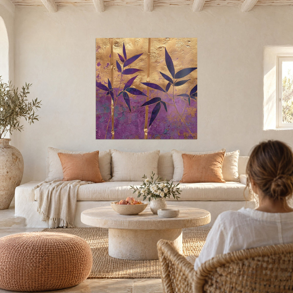 Tableau bambou aux feuilles violettes sur fond d'or martelé, accroché au-dessus d'un canapé dans un salon lumineux