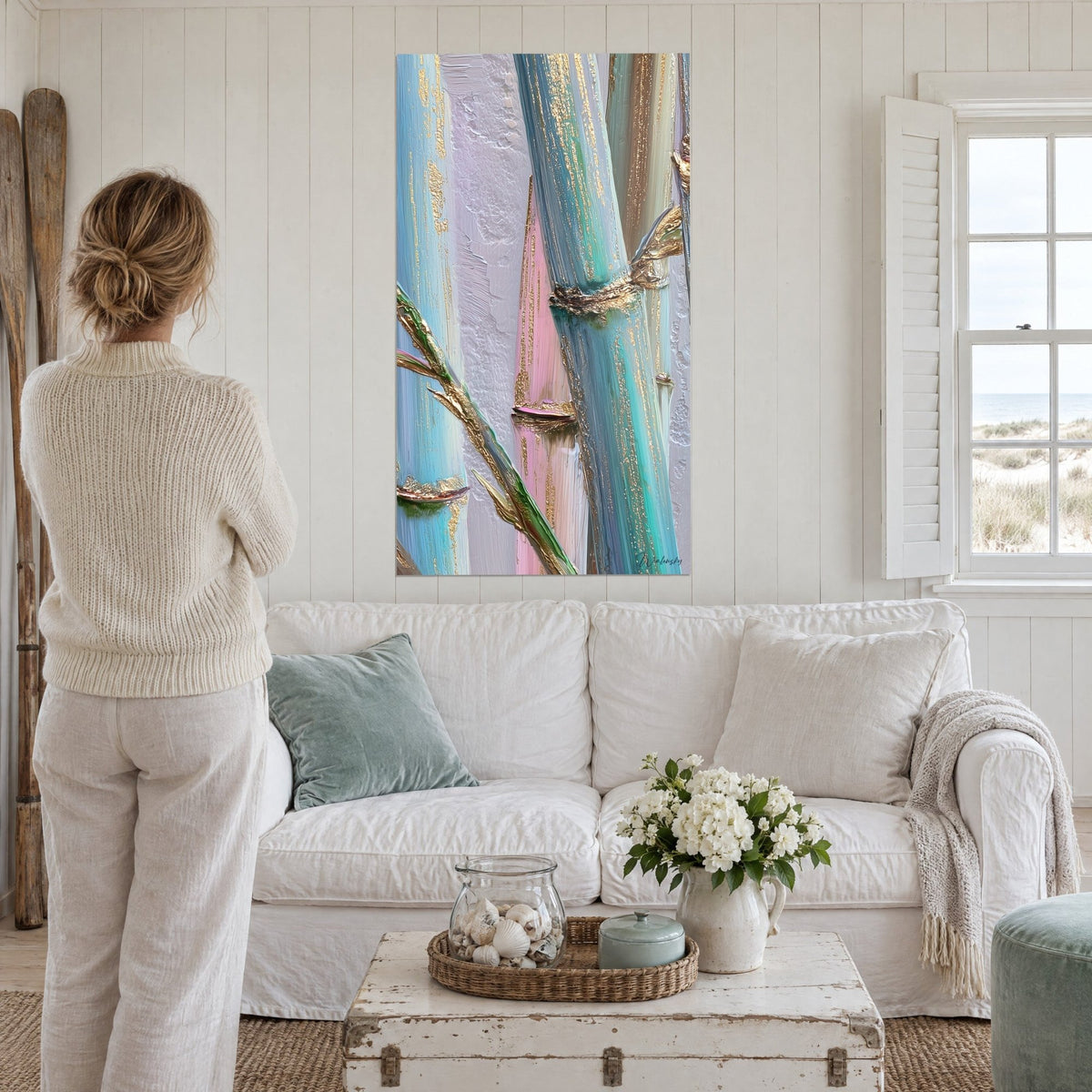 Tableau tiges de bambou turquoise et rose à nœuds dorés, accroché au-dessus d'un canapé dans un salon lumineux